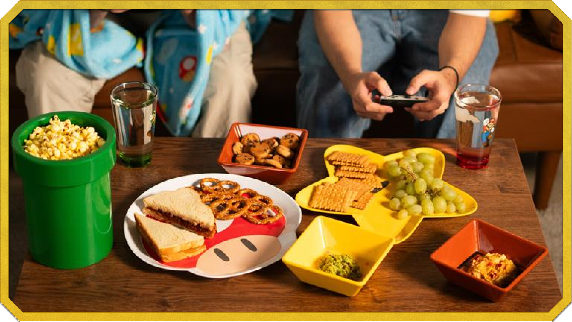 Friends playing with Joy Con and a table of Mario home goods